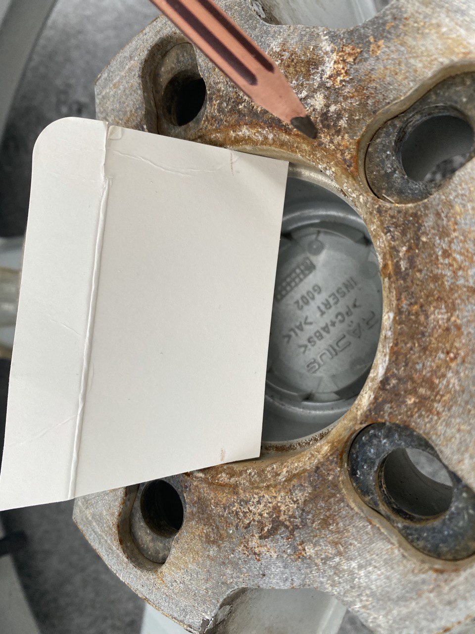 Cardboard wedge inserted in wheel center bore